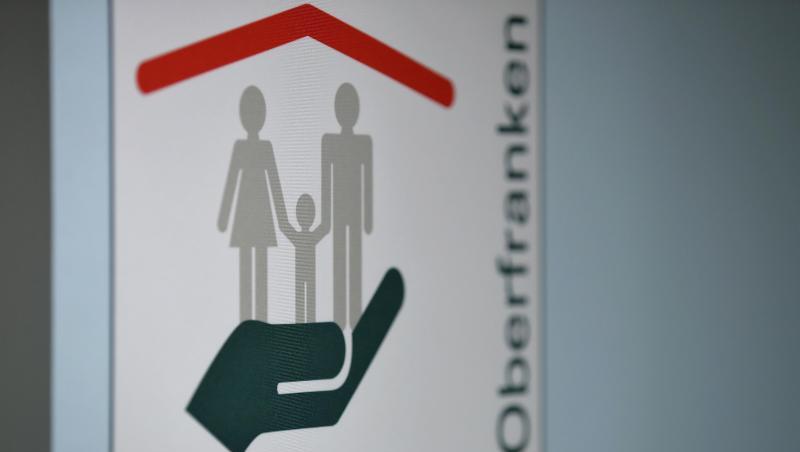 Anker-Einrichtung Oberfranken steht auf einem Banner in den Verwaltungsräumen des Ankerzentrums für Geflüchtete. Foto: Daniel Karmann/Archiv Anker-Einrichtung Oberfranken steht auf einem Banner in den Verwaltungsräumen des Ankerzentrums für Geflüchtete. Foto: Daniel Karmann/Archiv