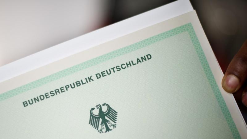 Ein Mann hält eine Einbürgerungsurkunde in der Hand. Foto: Julian Stratenschulte/dpa/Symbolbild Ein Mann hält eine Einbürgerungsurkunde in der Hand. Foto: Julian Stratenschulte/dpa/Symbolbild