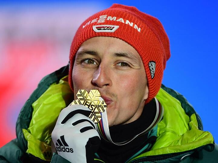 Bei der Siegerehrung küsst Eric Frenzel seine Goldmedaille.