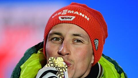 Bei der Siegerehrung küsst Eric Frenzel seine Goldmedaille.