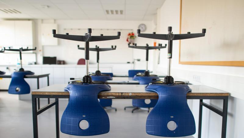 Stühle stehen in einem leeren Klassenzimmer in einem Gymnasium auf den Tischen, da der Unterricht in der Corona-Zeit ausgefallen ist.