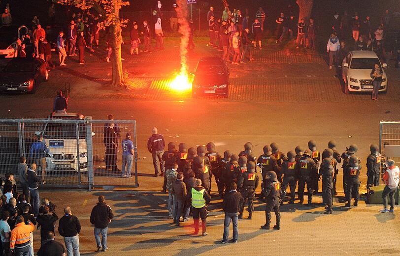 Nach dem Spiel belagern Fans die Geschäfststelle des KSC und zünden Feuerwerkskörper.