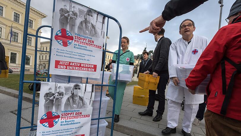 Die Organisatoren des Volksbegehrens "Stoppt den Pflegenotstand" überreichen vor dem bayerischen Innenministerium die Kisten mit den gesammelten Unterschriftenlisten. Die Organisatoren des Volksbegehrens "Stoppt den Pflegenotstand" überreichen vor dem bayerischen Innenministerium die Kisten mit den gesammelten Unterschriftenlisten.