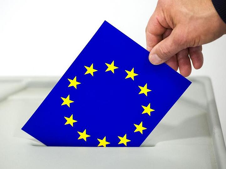 Ein Mann steckt eine Karte mit dem Aufdruck der Europafahen in den Schlitz einer Wahlurne. Foto: Patrick Pleul/Archivbild