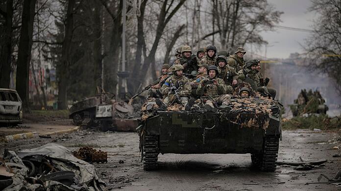 Ukrainische Soldaten durchfahren den Ort Butscha.
