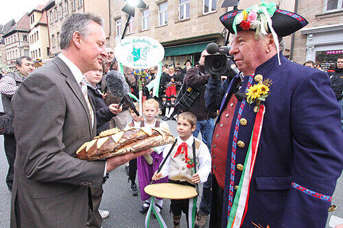 Damit kann er das ganze Rathaus versorgen: Fürths OB Thomas Jung (links) bekam von Sebastian (8, Mitte) einen riesigen Laib Brot überreicht.