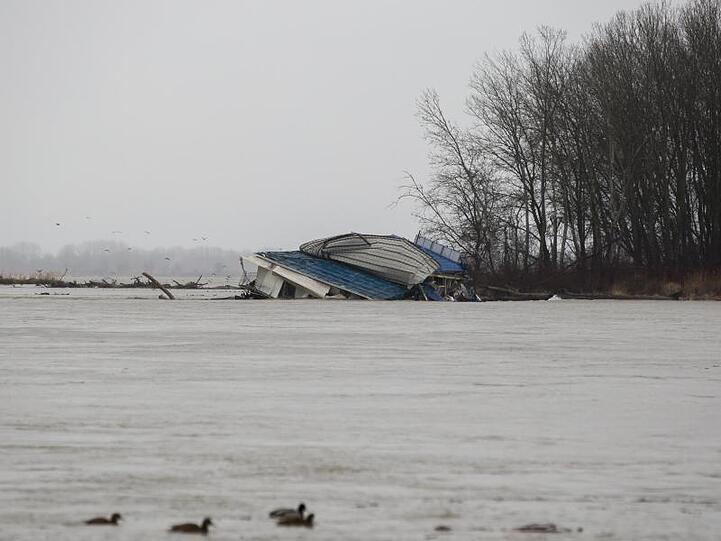 Ein Ponton mit einem ganzen Flussrestaurant löst sich vom Donauufer und treibt flussabwärts.