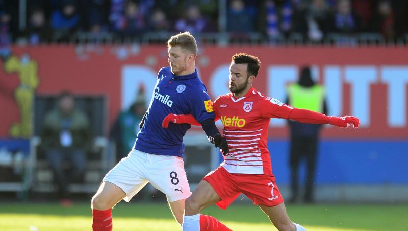 Kiels Alexander Mühling (l) und Regensburgs Albion Vrenezi kämpfen um den Ball. Foto: Daniel Bockwoldt Kiels Alexander Mühling (l) und Regensburgs Albion Vrenezi kämpfen um den Ball. Foto: Daniel Bockwoldt