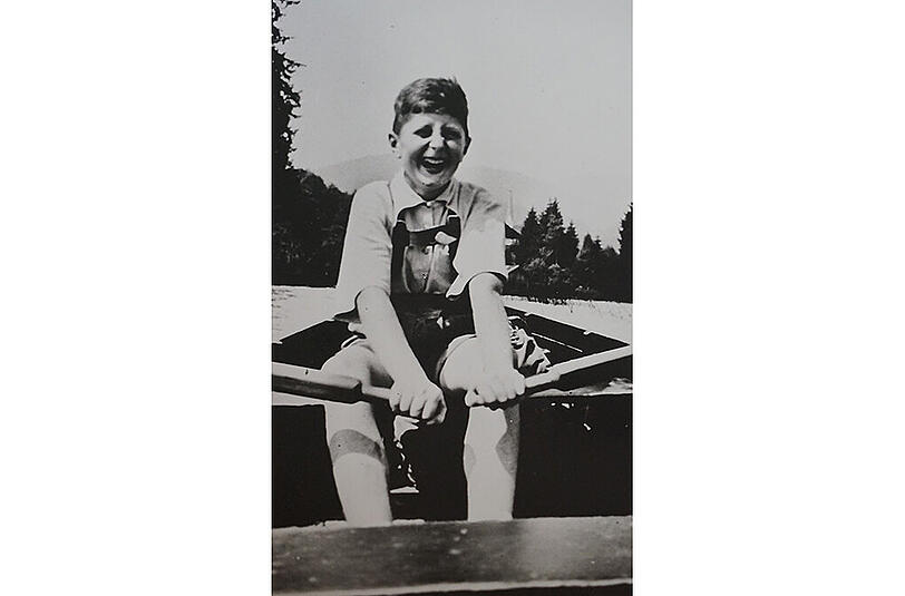 Nichts schöner als der Tegernsee: Das Bild ist 1937 auf dem Tegernsee entstanden. Da hat mein Onkel Arnold mich eingeladen zu einer ganztägigen Rundfahrt mit dem Ruderboot. Wir sind da sicher einige Stunden unterwegs gewesen. Meine Großmutter mütterlicherseits hatte einen alten Bauernhof in der Nähe von Miesbach. Als Witwe hat sie da die letzten 30 Jahre ihres Lebens verbracht. Ich war dann oft in den Ferien dort bei der Großmutter. Und mit dem Onkel Arnold habe ich oft Ausflüge unternommen. Das Rudern hat mir richtig Spaß gemacht. Wir sind in Gmund gestartet und sind dann eine große Runde gerudert.