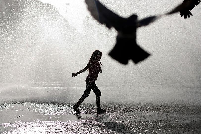Kühl-Faktor Brunnen: Ein Mädchen spielt am Stachus. Das Wasser hilft im Kleinen bei der Temperaturregulierung.