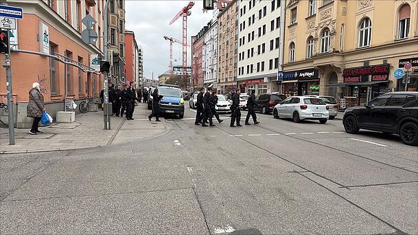 Polizeikräfte bewegen sich geschlossen durch die Straße und überprüfen Lokale und Betriebe. Polizeikräfte bewegen sich geschlossen durch die Straße und überprüfen Lokale und Betriebe.