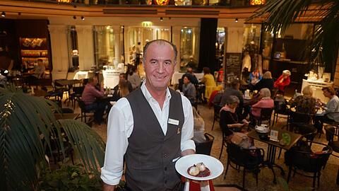 Oberkellner Muhamed Krasniqi, hier mit dem Dessert, arbeitet seit 30 Jahren im Café Luitpold und ist damit fast schon so sehr Tradition wie das Kaffeehaus selbst.