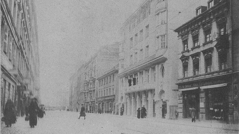 Das Foto zeigt die Dachauer Straße. Hinten, am Ende der Straße, ist der Stiglmaierplatz. Das große, helle Gebäude auf der rechten Seite zeigt den gerade eröffneten Regina-Kinopalast. Heute ist darin das Theater für Kinder untergebracht. Das Foto stammt aus dem Jahr 1912.