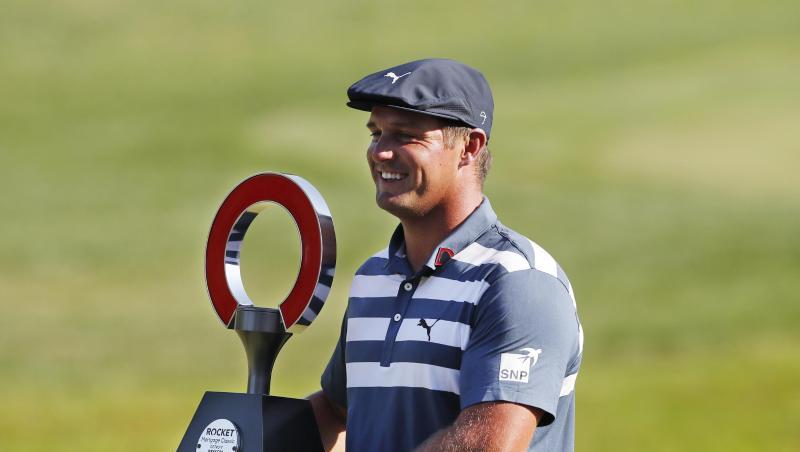 Bryson DeChambeau hält die Trophäe des Golfturniers Rocket Mortgage Classic in den Händen. Bryson DeChambeau hält die Trophäe des Golfturniers Rocket Mortgage Classic in den Händen.