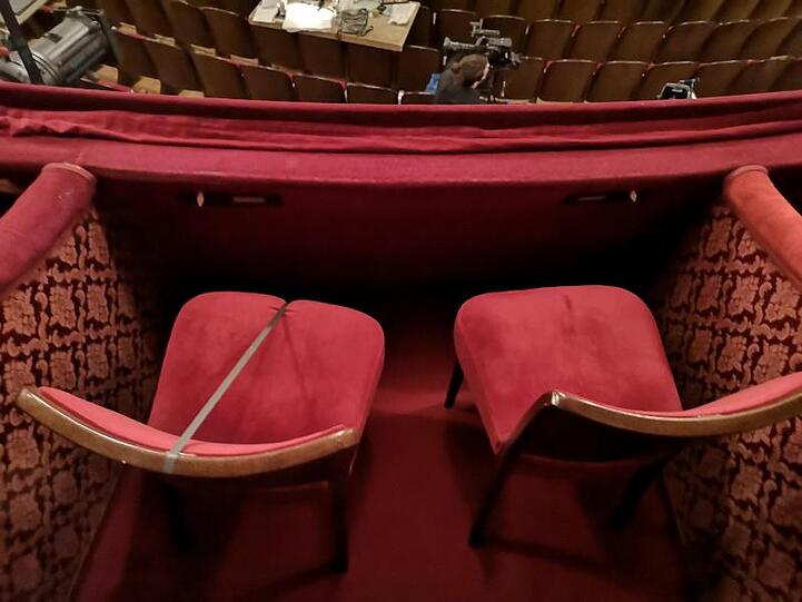Um Abstand zu gewähren ist jeder zweite Sitzplatz im Landestheater Salzburg mit einem Gurt gesperrt. Foto: Barbara Gindl/APA/dpa/Archivbild