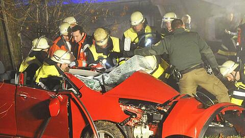 Helfer bergen an der Unfallstelle die beiden Brüder aus dem total zerstörten Wrack des Honda Jazz