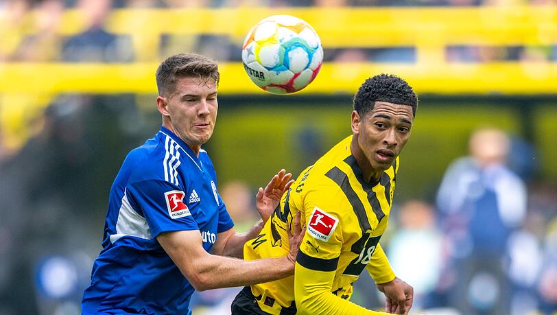 Schalkes Florian Flick (l) und Dortmunds Jude Bellingham kämpfen um den Ball.