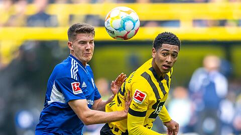 Schalkes Florian Flick (l) und Dortmunds Jude Bellingham kämpfen um den Ball.