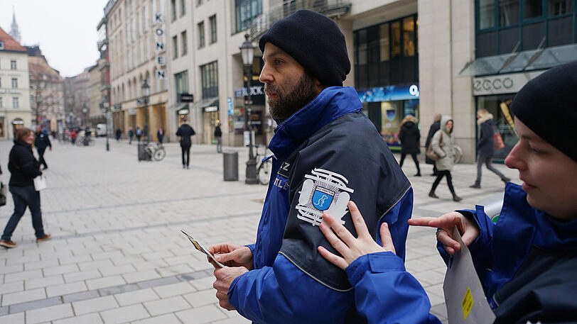 Pelzermittler V.li. Michael Seitz (39) und Jennifer Schopf beim Abdecken des Emblems auf ihren Pelz-Ermittler Outfits - Die Münchner Polizei wollte, dass etwas überklebt wird.