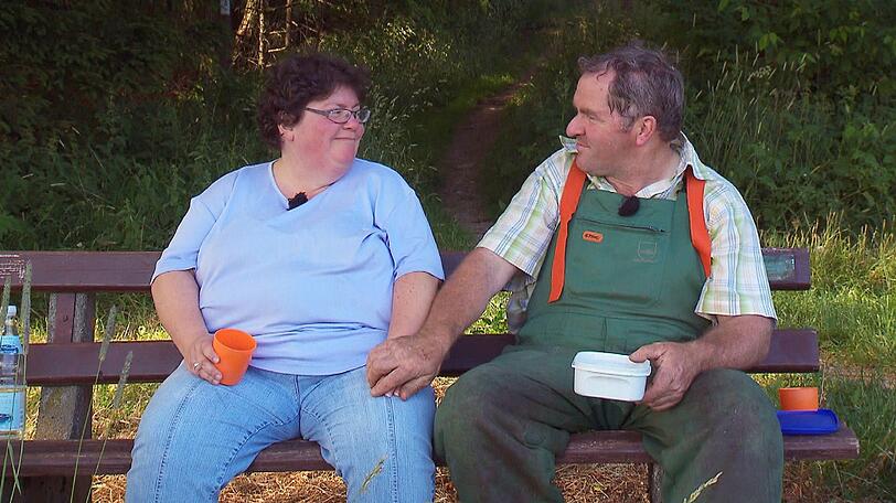 Der herzliche Hesse Albert (52) und Sabine (47) aus Bayern genießen die Aussicht bei einem Picknick im Wald.