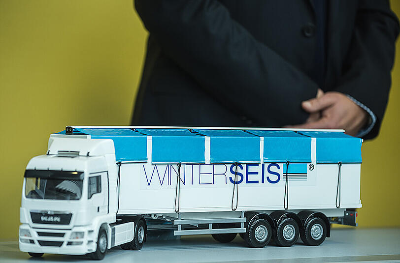 Eine spezielle Schnee- und Eisräumvorrichtung für Lastwagen. Der Fahrer des LKW kann die Planen an den Seilen nach unten ziehen, um das Dach des Anhängers von Schnee und Eis zu befreien. Damit soll verhindert werden, dass Eisplatten auf der Autobahn vom Dach geweht werden, welche dann auf den dahinter fahrenden Autos landen könnten.