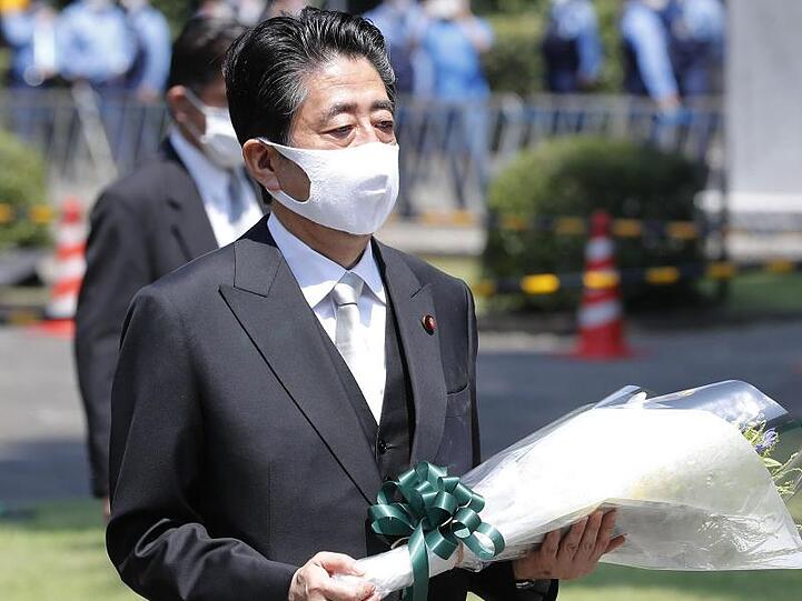 Shinzo Abe, Ministerpräsident von Japan, trägt einen Blumenstrauß, den er auf dem Chidorigafuchi Nationalfriedhof für die nicht identifizierten Überreste der Kriegstoten niederlegt. Japan feiert den 75. Jahrestag seiner Kapitulation im Zweiten Weltkrieg.