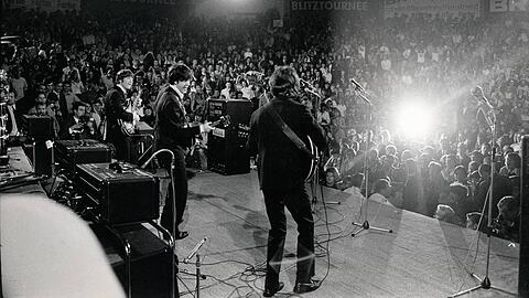John Lennon, Paul McCartney und George Harrison haben sichtlich Spaß im Circus Krone, die Zuschauer im vollbesetzten Rund ebenfalls.