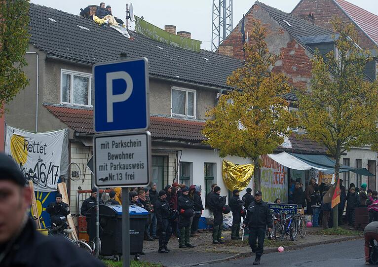 Die Besetzer werfen Konfetti, unten steht ein SEK-Kommando der Polizei: In Greifswald wurde ein besetztes Haus geräumt. Die Bilder.
