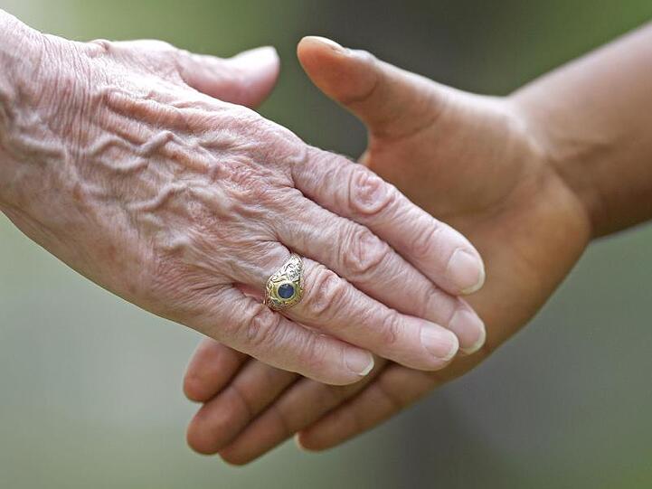 Zwei Personen geben sich die Hand. Foto: Uwe Anspach/dpa/Archiv