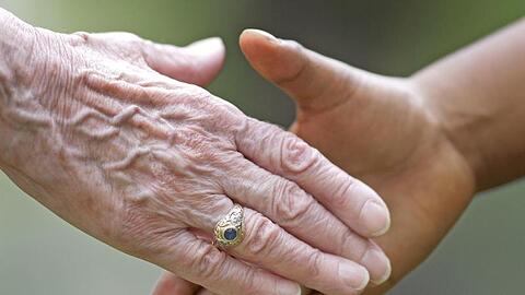 Zwei Personen geben sich die Hand. Foto: Uwe Anspach/dpa/Archiv