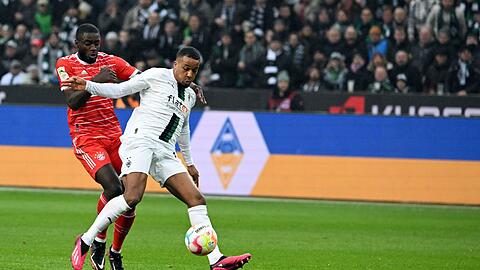 Mönchengladbachs Alassane Plea (r)wird von Bayerns Dayot Upamecano gefoult.