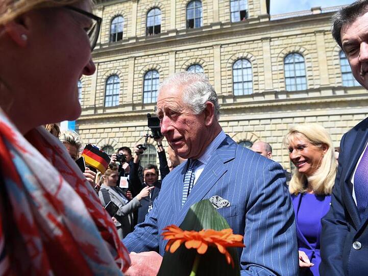 Prinz Charles (M) begrüßt die Menschen bei seiner Ankunft zu einem Empfang in der historischen Residenz. Foto: Matthias Balk