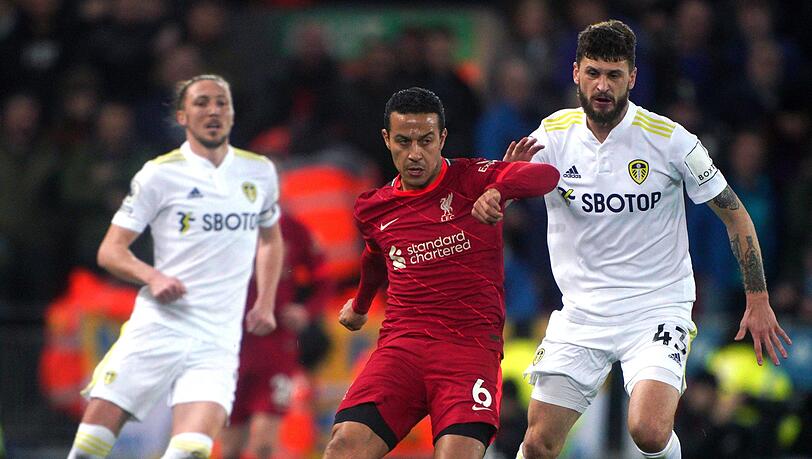 Thiago Alcantara (M) vom FC Liverpool kommt vor Sam Greenwood (r) von Leeds United an den Ball.