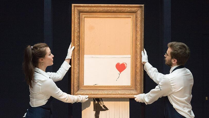 Banksys Girl kurz nach der ersten Auktion 2018. Das mittlerweile als "Love is in the Bin" bezeichnete Werk kam damals für mehr als eine Million Pfund unter den Hammer - dann schredderte es sich. 2021 wurden das Werk für mehr als 18 Millionen Pfund versteigert, und diese Version ist jetzt in München zu sehen. Banksys Girl kurz nach der ersten Auktion 2018. Das mittlerweile als "Love is in the Bin" bezeichnete Werk kam damals für mehr als eine Million Pfund unter den Hammer - dann schredderte es sich. 2021 wurden das Werk für mehr als 18 Millionen Pfund versteigert, und diese Version ist jetzt in München zu sehen.