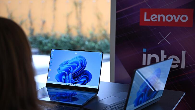 Zwei Lenovo-Laptops, die jeweils zwei Bildschirme haben: Rechts ist der zweite Bildschirm auf der R&uuml;ckseite des ersten Bildschirms und links sind die beiden Bildschirme nebeneinander montiert - einer liegt vor der Tastatur und dahinter steht der zweite Bildschirm.