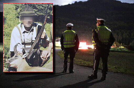 Polizeibeamte stehen am Abend vor der Zufahrt zum Anwesen des Killers. Nach dem Massaker wurde im Keller eine verbrannte Leiche gefunden. Handelt es sich um den Killer Alois H.? (links)