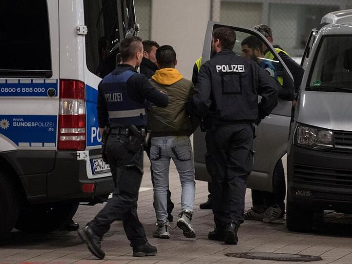 Polizisten bringen einen jungen Mann aus Afghanistan zur Abschiebung zum Frankfurter Flughafen.
