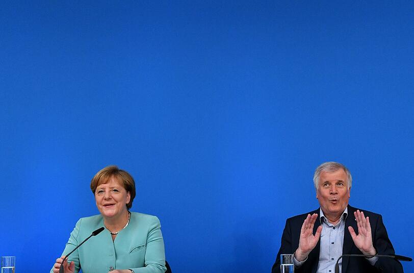 Wenn die Kanzlerin spricht, hat der CSU-Chef Zeit für Späßchen. Die Bilder-Kombo zeigt Angela Merkel, als sie mit Horst Seehofer die Ergebnisse der Klausur bei einer Pressekonferenz vorstellt.