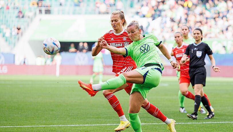 Wolfsburgs Alexandra Popp (r) schießt neben Münchens Maximiliane Rall (l).