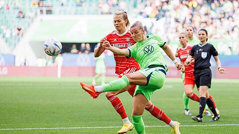 Wolfsburgs Alexandra Popp (r) schießt neben Münchens Maximiliane Rall (l).