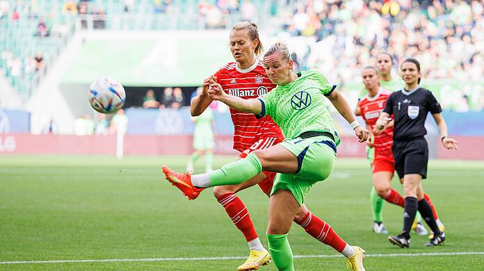 Wolfsburgs Alexandra Popp (r) schießt neben Münchens Maximiliane Rall (l).