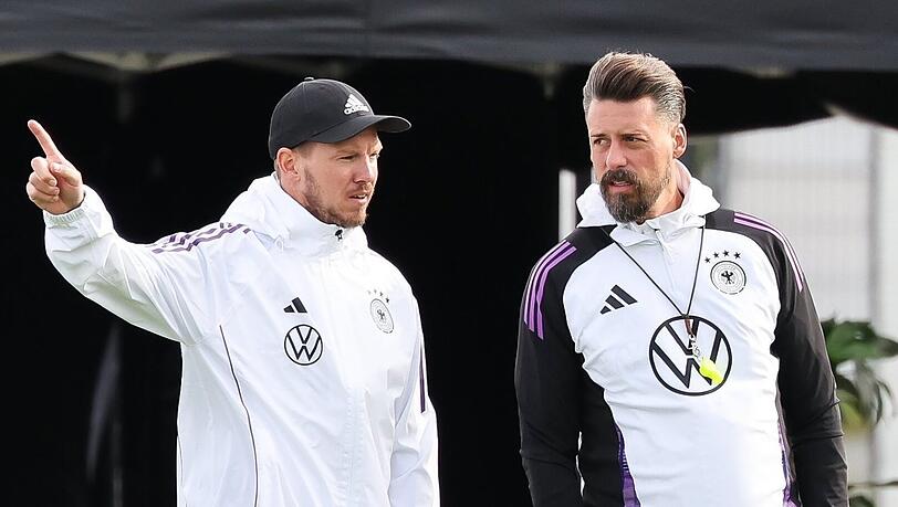 Deutschlands Trainer Julian Nagelsmann (l) und Assistenztrainer Sandro Wagner verfolgen das Training.