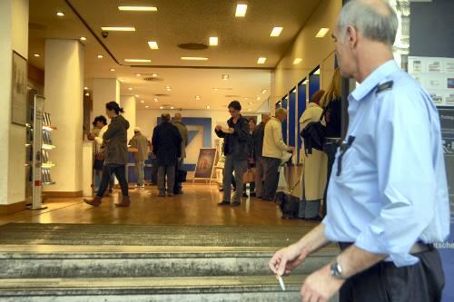 Normaler Betrieb in Münchner Banken &ndash; nur ein Wachmann weiß: Es tut sich mehr als sonst.