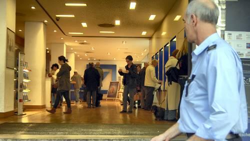 Normaler Betrieb in Münchner Banken – nur ein Wachmann weiß: Es tut sich mehr als sonst. Normaler Betrieb in Münchner Banken – nur ein Wachmann weiß: Es tut sich mehr als sonst.