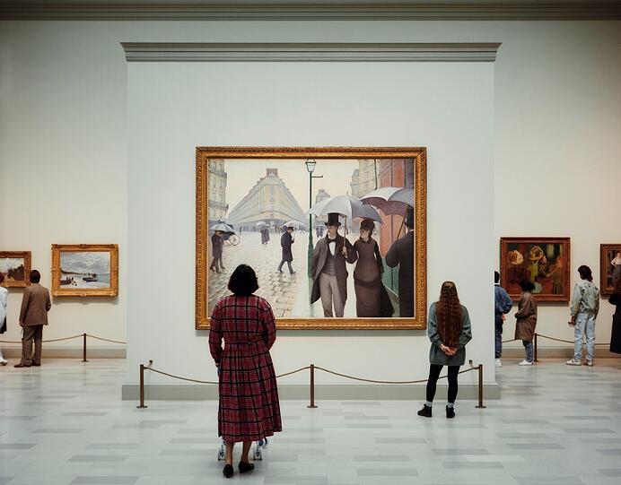 Thomas Struth hat das „Art Institute of Chicago“ 1990 aufgenommen. Die Besucherin mit Gehwagerl steht vor einer Pariser Straßenszene von Gustave Caillebotte.