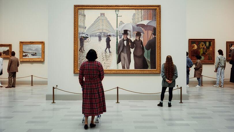 Thomas Struth hat das „Art Institute of Chicago“ 1990 aufgenommen. Die Besucherin mit Gehwagerl steht vor einer Pariser Straßenszene von Gustave Caillebotte. Thomas Struth hat das „Art Institute of Chicago“ 1990 aufgenommen. Die Besucherin mit Gehwagerl steht vor einer Pariser Straßenszene von Gustave Caillebotte.