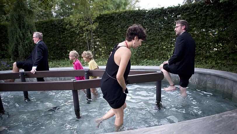Formell trifft informell: Festspielbesucher in der Kneippanlage des Freibads Bürgerreuth hinter dem Festspielhaus auf dem „Grünen Hügel“ in Bayreuth. Formell trifft informell: Festspielbesucher in der Kneippanlage des Freibads Bürgerreuth hinter dem Festspielhaus auf dem „Grünen Hügel“ in Bayreuth.