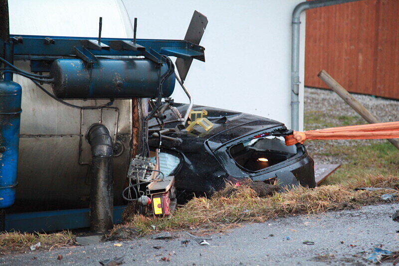 Ein mit 25 Tonnen Rahm beladener Lkw stößt am Sonntagmorgen mit einem BMW zusammen, stürzt in einen Graben und begräbt das Auto halb unter sich.