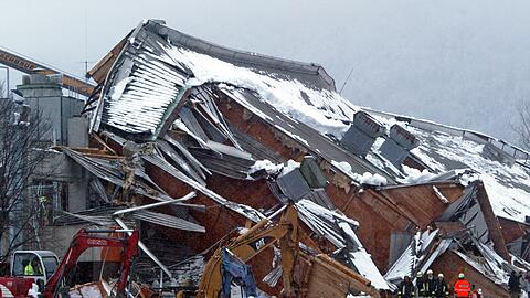Mit Baggern trugen die Rettungskr&auml;fte die Tr&uuml;mmer der eingest&uuml;rzten Eishalle in Bad Reichenhall ab. (Archivbild)