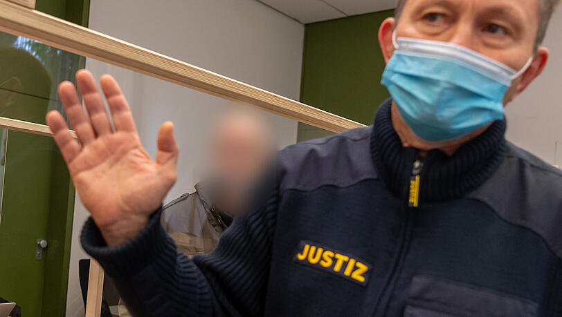 Im Hintergrund ist der Angeklagte zu sehen. Im Hintergrund ist der Angeklagte zu sehen.
